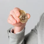 Asmuo laiko Bitcoin monetą. Kriptovaliuta, finansai, investicija.