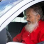 Garbino amžiaus žmogus prie vairo