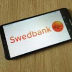 Swedbank logotipas telefone / Piotr Swat / Shutterstock.com